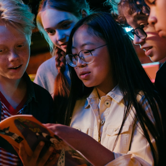 group of middle school students reading magazine